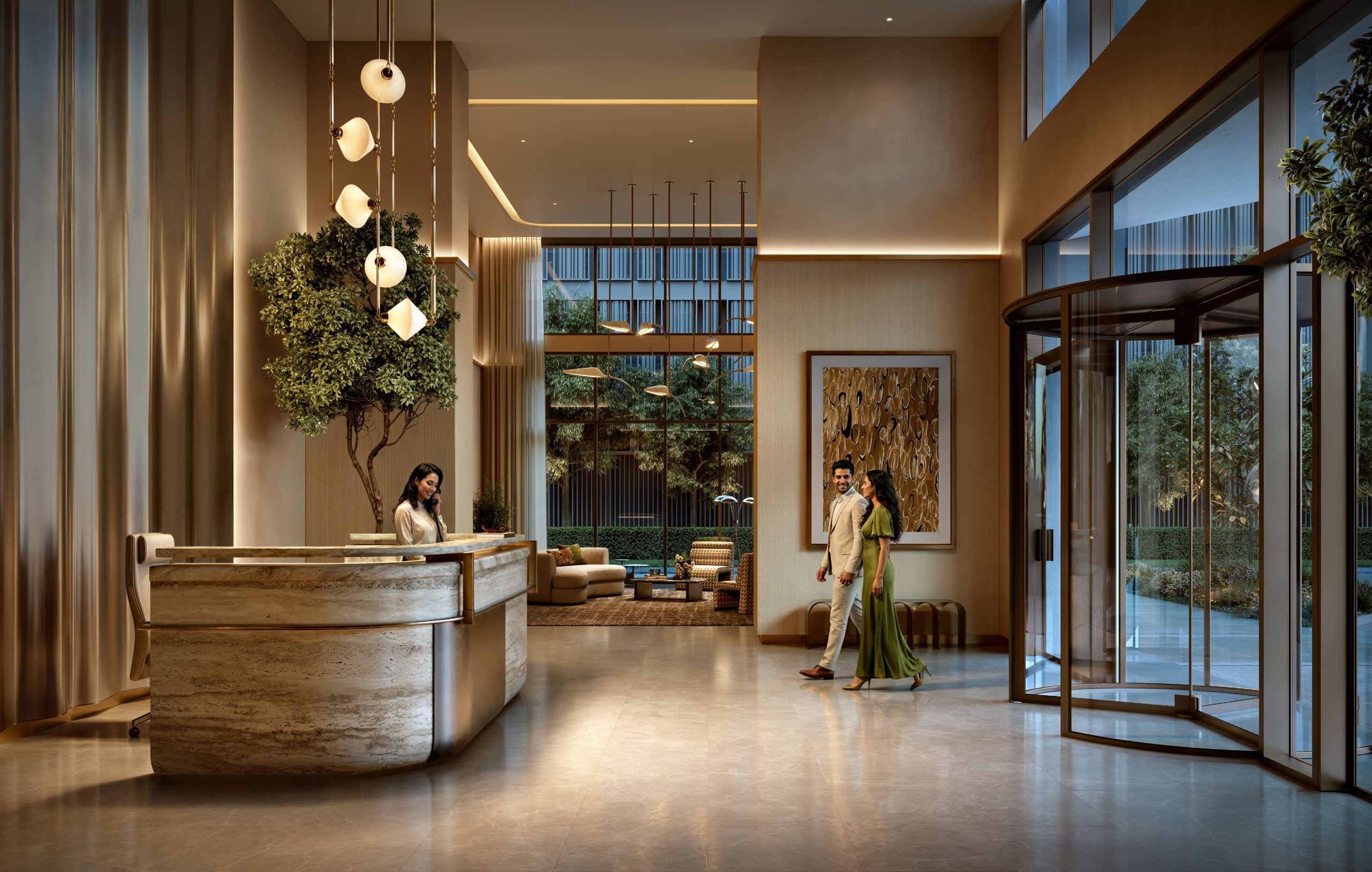 Lobby with travertine reception desk, pendant lights, indoor tree and revolving door